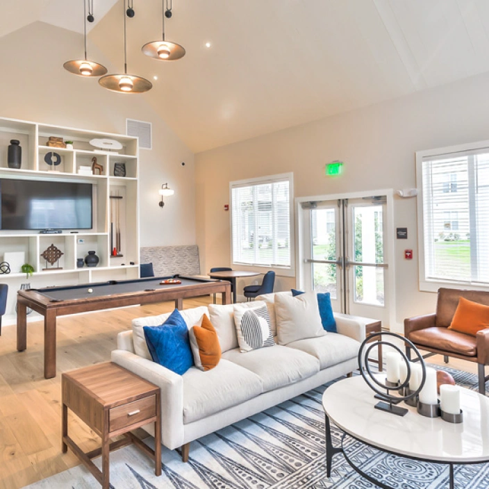 Modern clubhouse interior with pool table, comfortable sofas, and contemporary decor accents