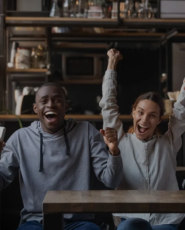 Energetic couple expressing excitement during a fun moment inside a casual restaurant setting