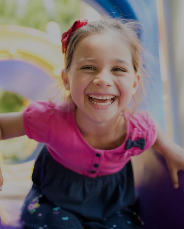 Happy child enjoying outdoor playtime at park with bright equipment and natural light