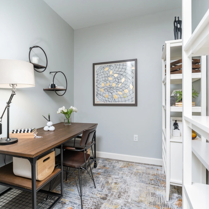 Cozy home office with wood desk, wall art, and modern shelving for decorative storage